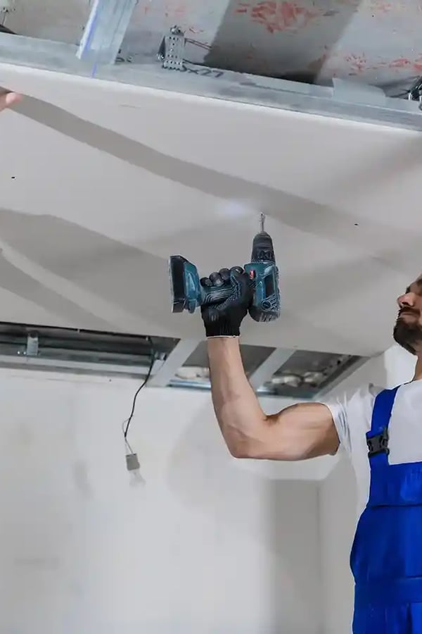 Pose de faux plafond en cours sur un chantier IsoLaire